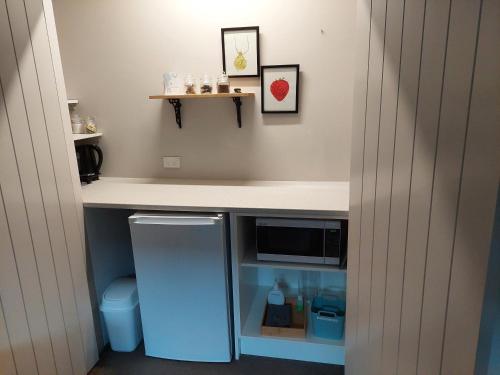 a small kitchen with a counter and a refrigerator at The Grey Studio@13a in Carterton