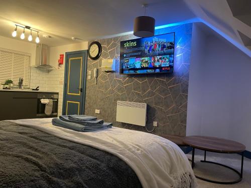 a bedroom with a bed with a tv on the wall at Lovely studio apartment located in Birmingham in Birmingham