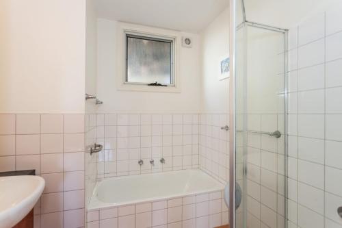 La salle de bains est pourvue d'une baignoire et d'un lavabo. dans l'établissement Seamist elevated with an amazing outlook, à Lorne