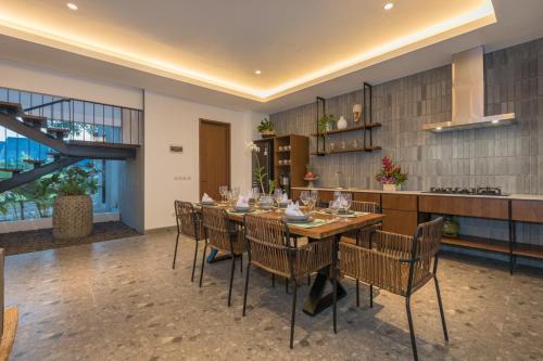 a dining room with a long table and chairs at Villa Daun 3 Canggu by Premier Hospitality Asia in Dalung