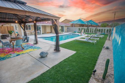 a backyard with a pool with a table and chairs at Rather Be Desert Getaway in Bermuda Dunes