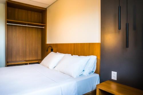 a bedroom with a bed with white pillows at Salinas Premium Resort in Salinópolis