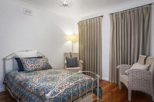 a bedroom with a bed and two chairs at Gunyha in Apollo Bay
