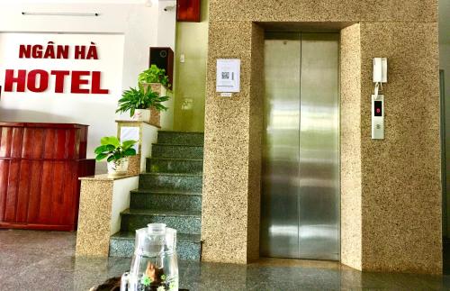 a hotel lobby with a glass door and stairs at khách sạn Ngân Hà in Tuy Hoa