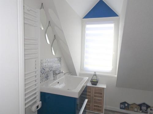 une salle de bain avec un lavabo et une fenêtre dans l'établissement Duplex in Plougasnou near Stunning Beaches, à Plougasnou