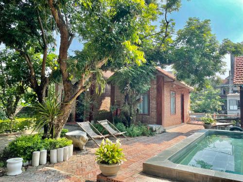 une arrière-cour avec une piscine et une maison dans l'établissement Anh Huong Tam Coc Homestay, à Ninh Binh