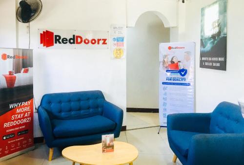 two blue chairs and a table in a room at RedDoorz @ El Cuarto SRP Talisay in Cebu City