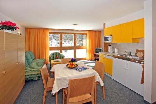 奧伯古格爾的住宿－博賽公寓酒店，厨房以及带桌椅的用餐室。