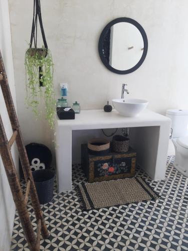 ein Bad mit einem Waschbecken und einem Spiegel in der Unterkunft Villa Paz Bali in Canggu