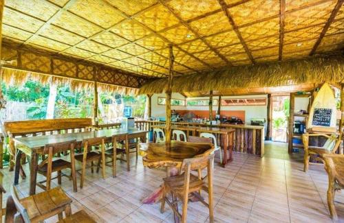 un restaurant avec des tables et des chaises en bois ainsi qu'un bar dans l'établissement Aventura Bed and Breakfast, à San Juan