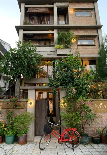 a red bike parked in front of a building at Kaia Gallery Hotel Hoi An in Hoi An