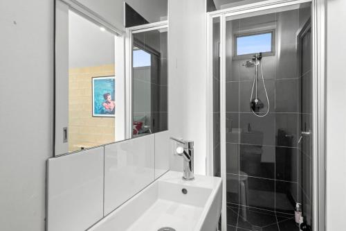 a white bathroom with a shower and a sink at Beach Baby in Aireys Inlet