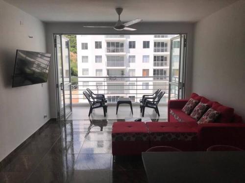 a living room with a red couch and a table and chairs at Acogedor apartamento en Girardot: Aqualina Orange in Girardot