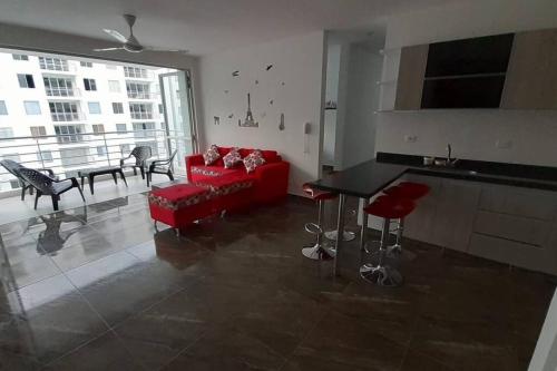 a living room with a red couch and a kitchen at Acogedor apartamento en Girardot: Aqualina Orange in Girardot