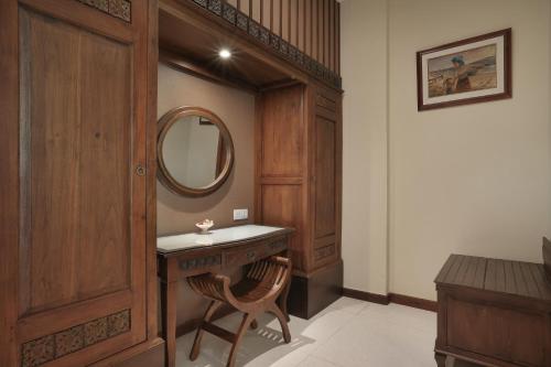 a bathroom with a wooden vanity and a mirror at Pelangi Bali Hotel & Spa in Seminyak