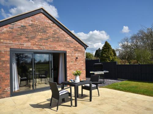a patio with a table and chairs and a piano at The Tyre Barn in Whitchurch