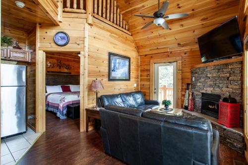 a living room with a couch and a bed in a cabin at Poolin Around with Private Hot Tub and Indoor Pool in Pigeon Forge