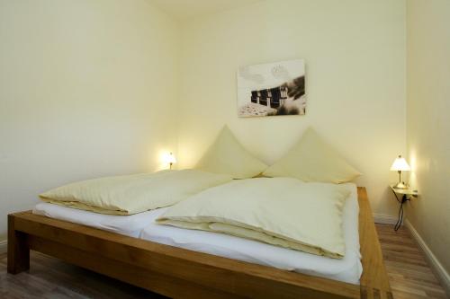 um quarto com uma cama com duas almofadas em Ferienwohnung Mare Nostrum 8 em Westerland