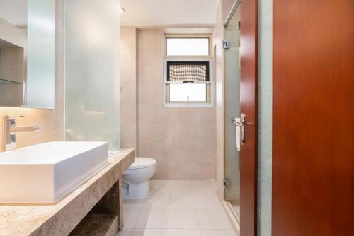 a bathroom with a sink and a toilet at Sanya Yikehai View Apartments in Sanya