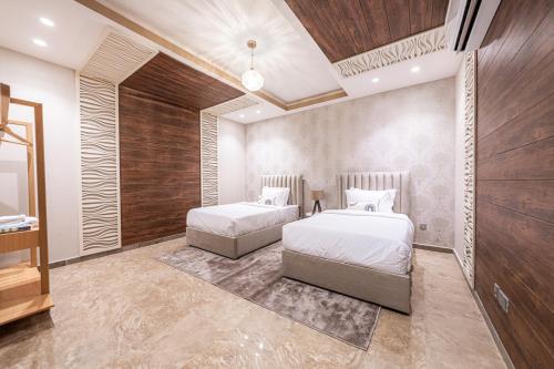 a bedroom with two beds and a mirror at Mabaat-Executive-Al Masarat Tower 257 in Jeddah