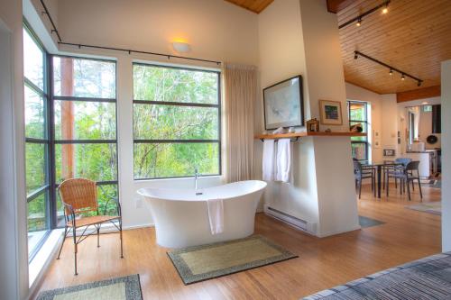 a bath tub in a room with a large window at Moon Dance Perch in Madeira Park