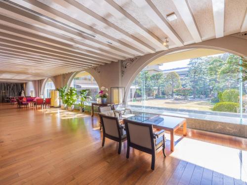 an open living room with a table and chairs at Sansuien in Kochi