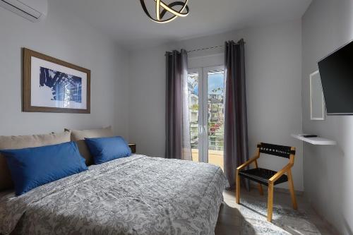 a bedroom with a bed and a chair and a window at Domenico Homes - City Center in Heraklio