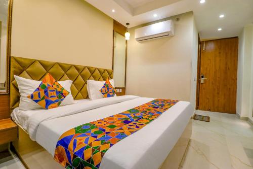 a bedroom with a large bed with a colorful blanket at FabHotel F9 Pitampura in New Delhi