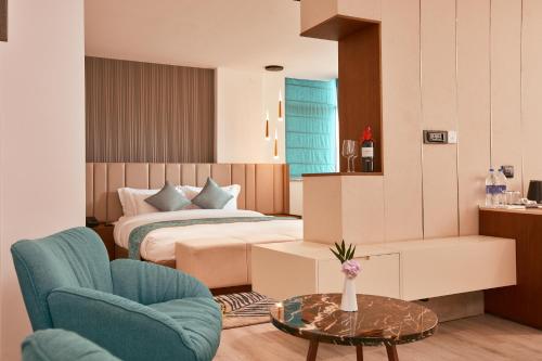 1 dormitorio con 1 cama, mesa y sillas en Indreni Suites, en Katmandú