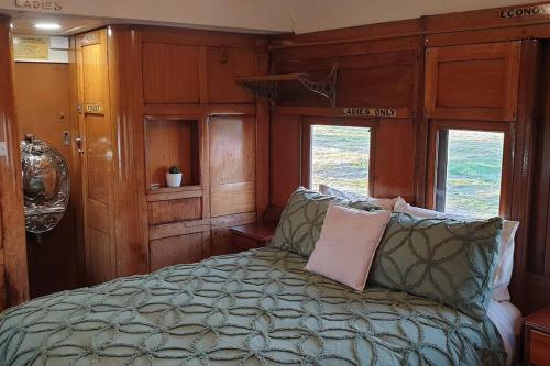 a bedroom with a bed in the back of a train at Carriages Waterfront in Wharparilla