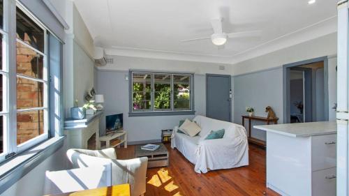 a living room with a couch and a table at Lazy Days Seaside Cottage - Umina Beach in Umina