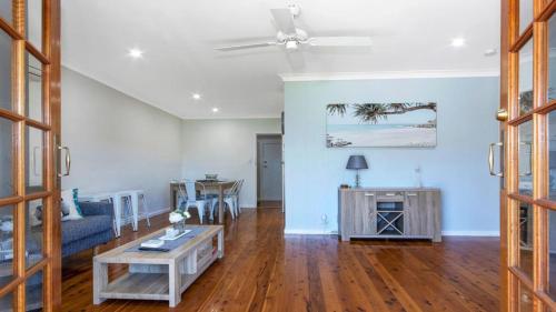 a living room with a couch and a table at Edendale Family Fun - Ettalong Beach in Ettalong Beach