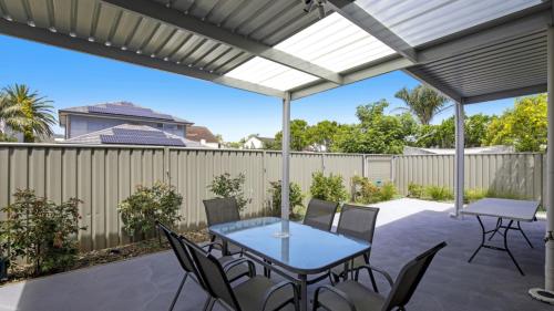 a patio with a blue table and chairs at Beachbound - Booker Bay Wifi in Booker Bay