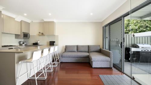 a living room with a couch and a kitchen at Beachbound - Booker Bay Wifi in Booker Bay