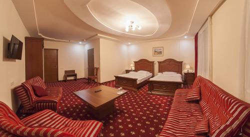 Gyumri Hotel في غيومري: غرفة في الفندق مع أريكة وسرير