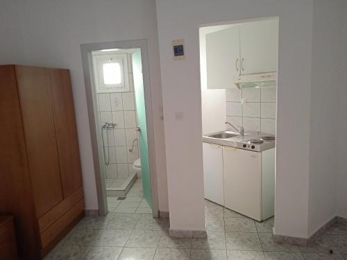 małą białą kuchnię ze zlewem i toaletą w obiekcie Villa Chrissa w Limenárii