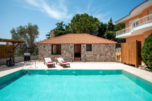 eine Villa mit einem Pool und einem Haus in der Unterkunft Filerolia Stone House in Pastida