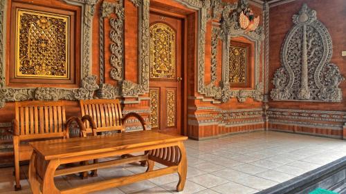 a room with a wooden table and two benches at Masainn Hotel Kuta in Kuta