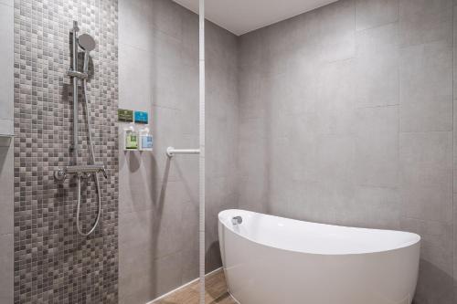 uma casa de banho com uma banheira branca e um chuveiro em Phoenix Hotel Taichung em Taichung