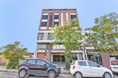 two cars parked in front of a building at Hotel Shakun Palace in Kota