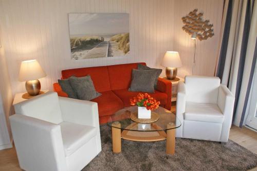 a living room with a couch and a chair at Blockhaus mit W LAN sehr strandnah in Damp