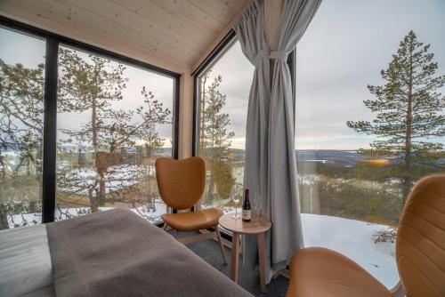 a bedroom with a bed and a large window at Lapland View Lodge in Övertorneå