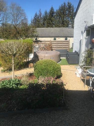 a garden with a dog laying on the ground at Loft exceptionnel à Wépion avec jacuzzi extérieur l été et cabine infrarouge in Wépion
