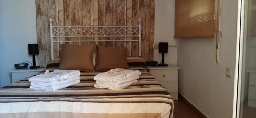 a bedroom with a bed with towels on it at Muy buena ubicación, cerca de la playa y céntrico. in Roquetas de Mar