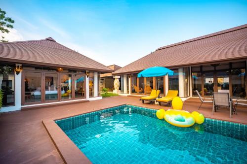 a swimming pool with inflatables and a house at Dhevan Dara Resort & Spa Hua Hin - Pool Villa in Hua Hin