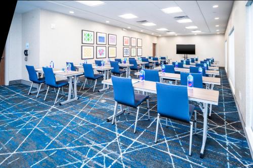 a conference room with tables and chairs and a screen at Holiday Inn Express & Suites - Rock Hill by IHG in Rock Hill