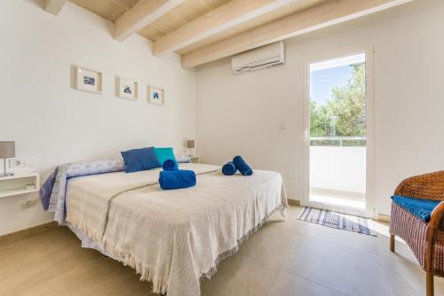 Un dormitorio con una cama con almohadas azules. en Els Arbocers 131-2 en Cala Blanca