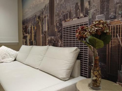 - un canapé blanc avec un vase de fleurs sur une table dans l'établissement Apartamento Costa II- Parking exterior privado incluido, à Zumaia