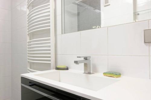 a white bathroom with a sink and a mirror at Topfloor Luxembourg Ville in Luxembourg