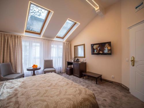 a bedroom with a bed and a desk and windows at The Moon Boutique Hotel in Sofia